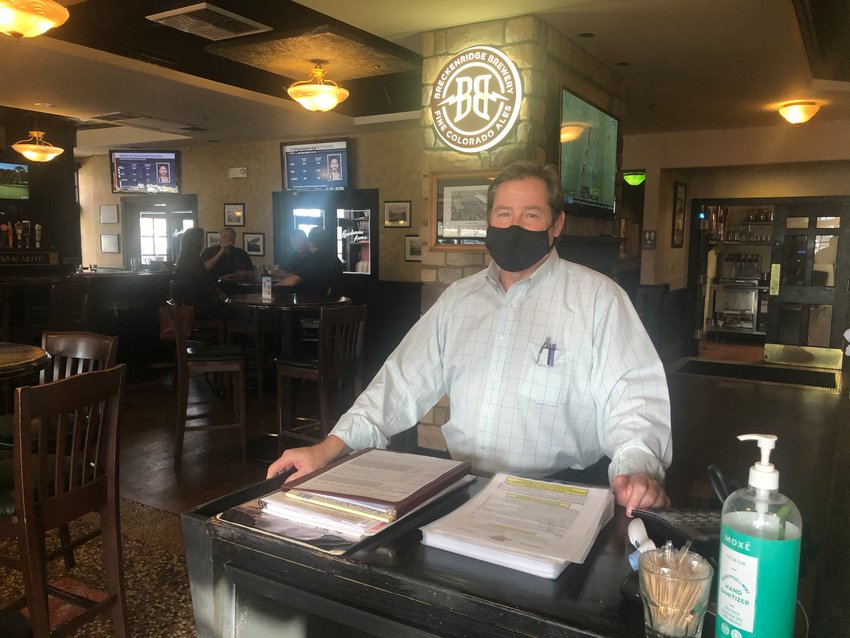 Chris Bogert, general manager at Landsdowne Arms in Highlands Ranch, stands behind the host desk at the restaurant just hours before indoor dining in the county became prohibited.